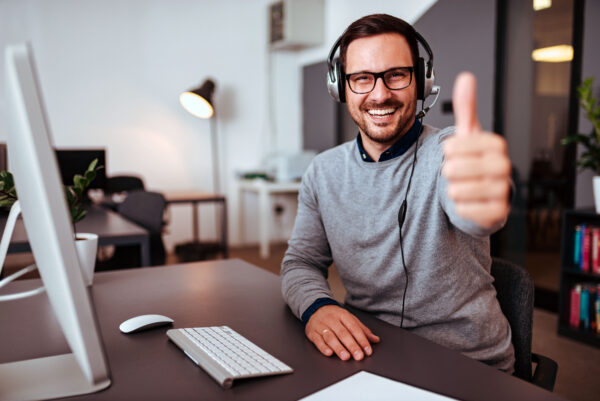 Portait of happy help desk operator showing thumbs-up. AdobeStock 231313483 1